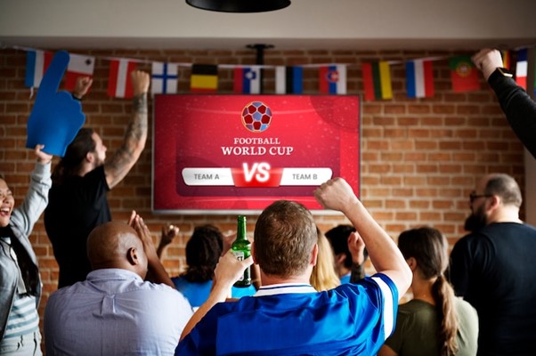 Cheerful supporters watching football at the pub