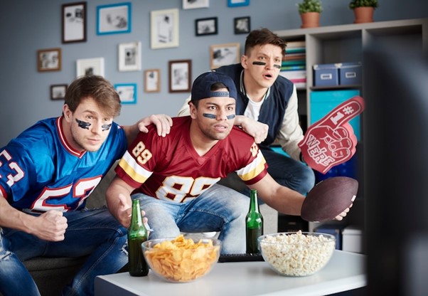 Group of friends watching football at home